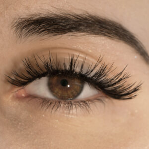 Close-up of a human eye wearing false eyelashes, showcasing the product's application.